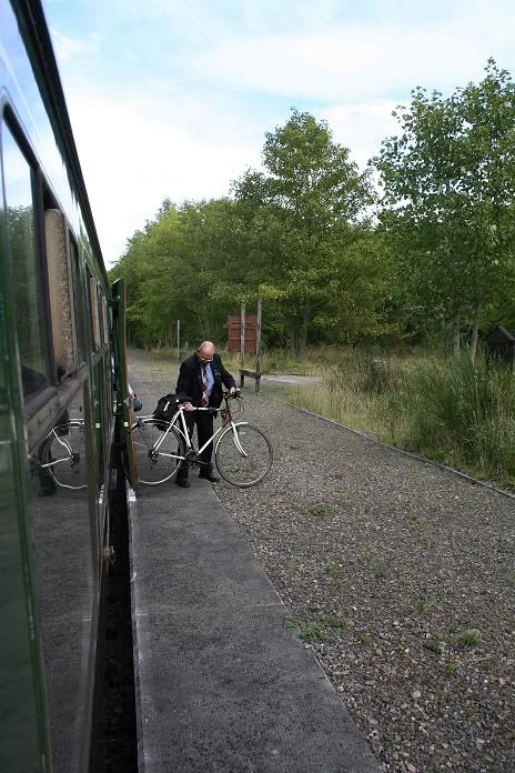 The guard removes a bicycle from the brakevan onto the platform
